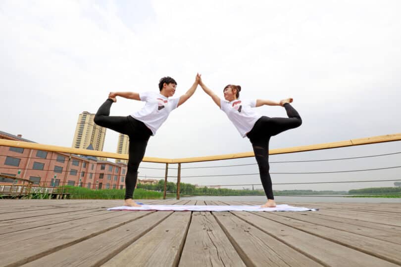 Duas pessoas fazendo Yoga em dupla.