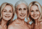Três mulheres por volta dos cinquenta anos sorrindo.