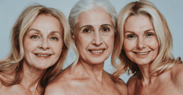 Três mulheres por volta dos cinquenta anos sorrindo.