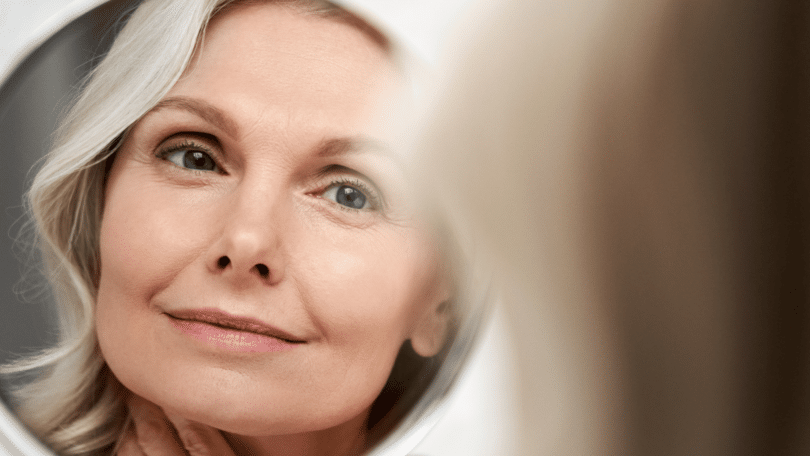 Mulher de meia idade se olhando no espelho