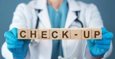 Médica segurando cubos em que está escrito "check-up"