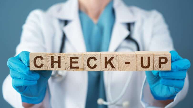 Médica segurando cubos em que está escrito "check-up"