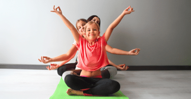 Crianças fazendo yoga com mulher jovem.