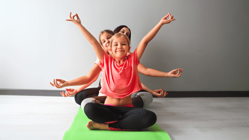 Crianças fazendo yoga com mulher jovem.