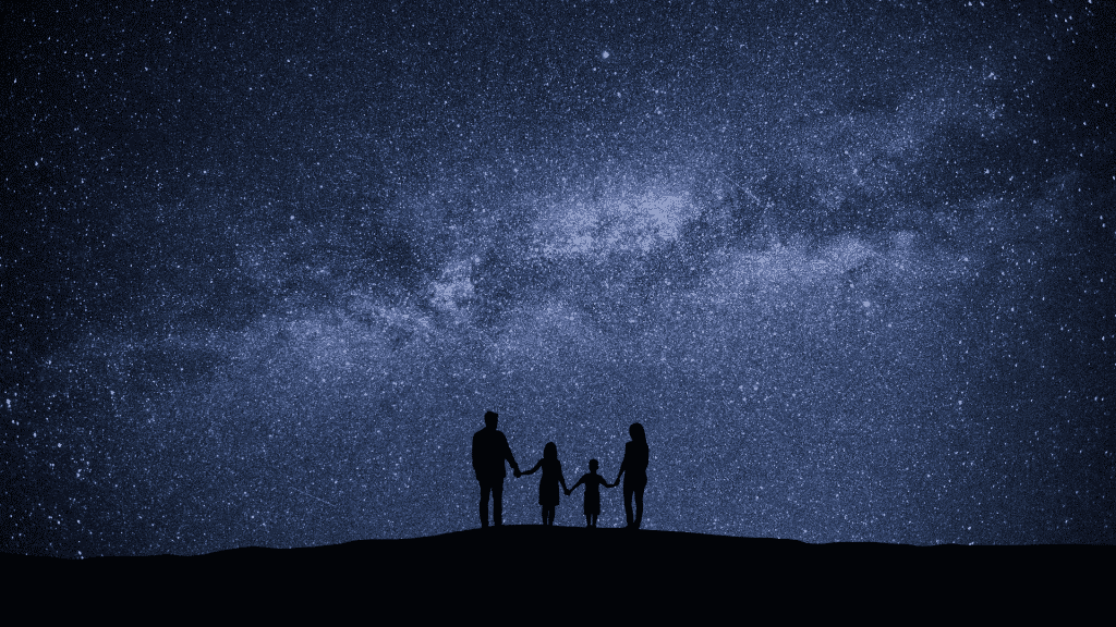 Família observando o céu noturno estrelado