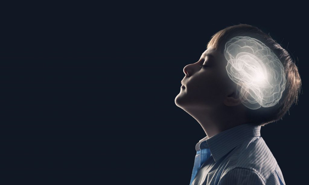 Ilustração do cérebro de uma criança brilhando em sua cabeça, vista de perfil.