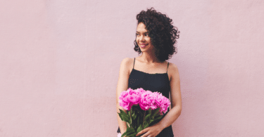 Mulher segurando buquê de flores de peônias rosas