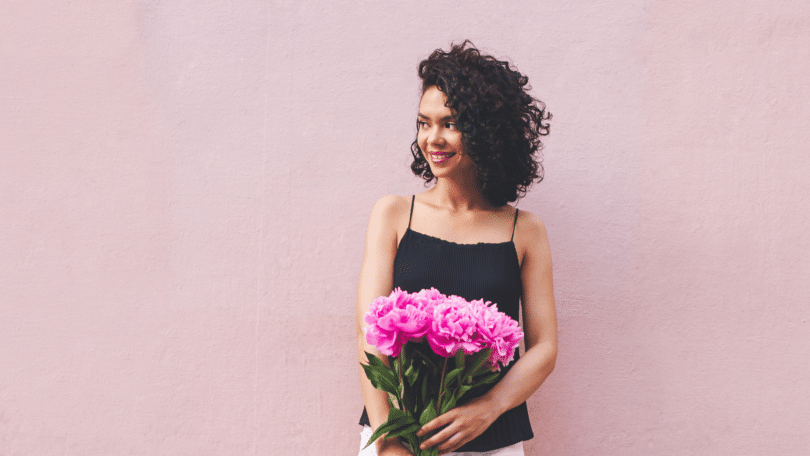 Mulher segurando buquê de flores de peônias rosas