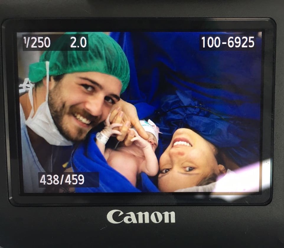 Foto tirada após o nascimento do bebê, junto aos seus pais no hospital.