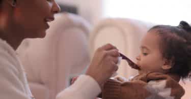 Mulher dando comida para bebê