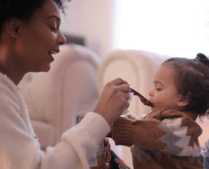 Mulher dando comida para bebê