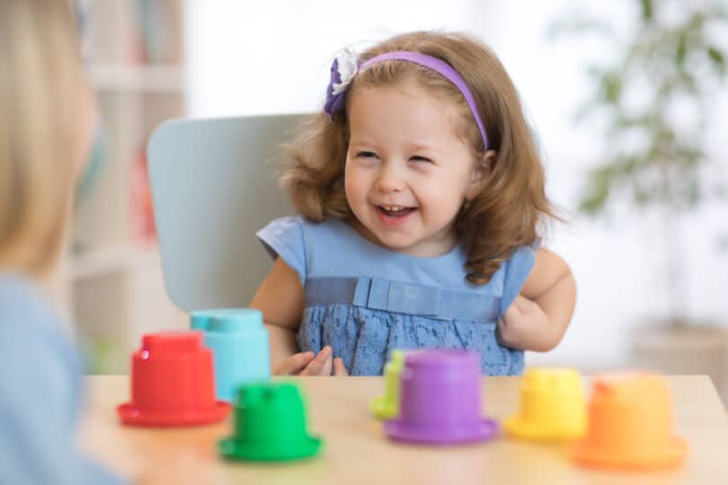 Criança brincando com brinquedos no cadeirão