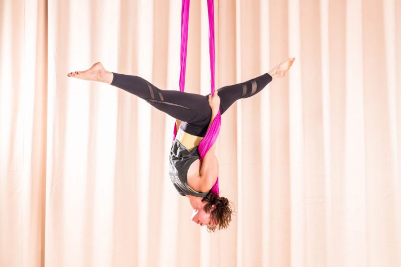 Mulher treinando Yoga Aéreo.