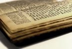Foto desfocada mostra páginas envelhecidas da bíblia hebraica.