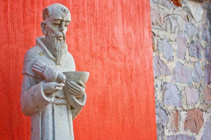 Estátua de São Francisco de Assis no lado de fora de uma igreja.