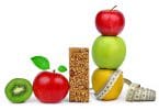 Frutas juntas, maçãs, kiwis, peras, perto de uma barrinha de cereal e uma fita métrica.