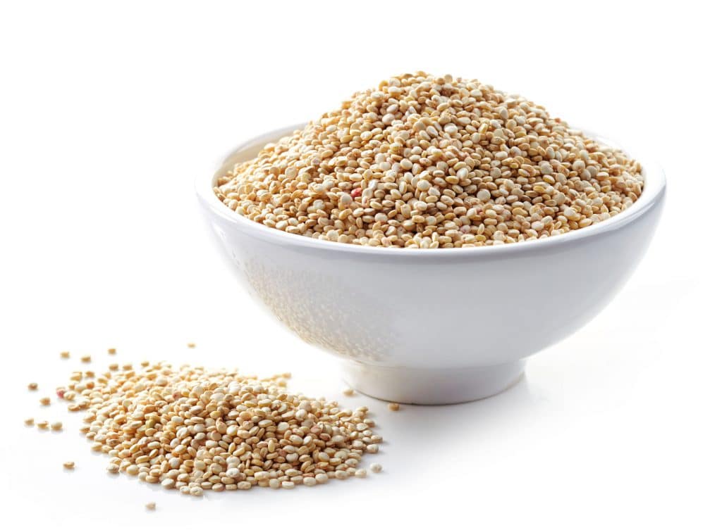 Uma vasilha branca com grãos de quinoa dentro.