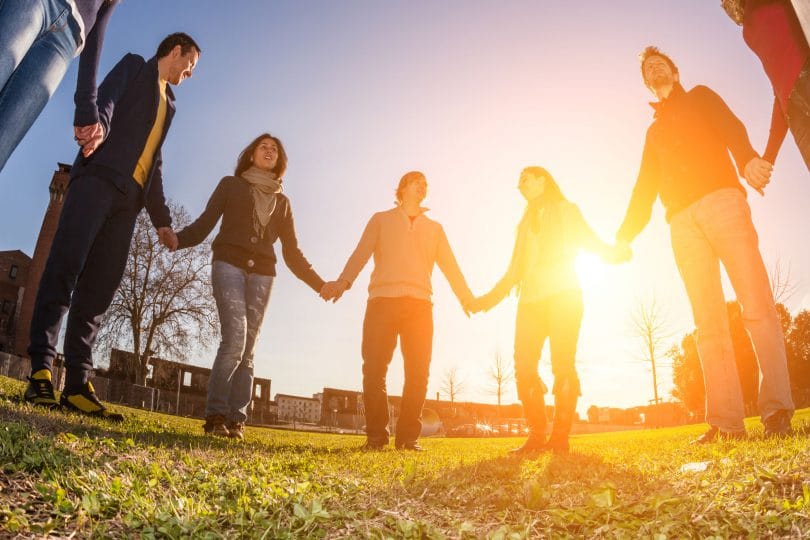 Pessoas de mãos dadas em um círculo.