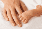 Mão de um bebê prematuro segurando o dedo de uma pessoa adulta