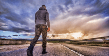 Homem andando por uma longa estrada