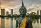 Estátua de Buda com lago e prédios ao fundo