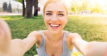 Mulher jovem sorridente fazendo selfie foto no parque.