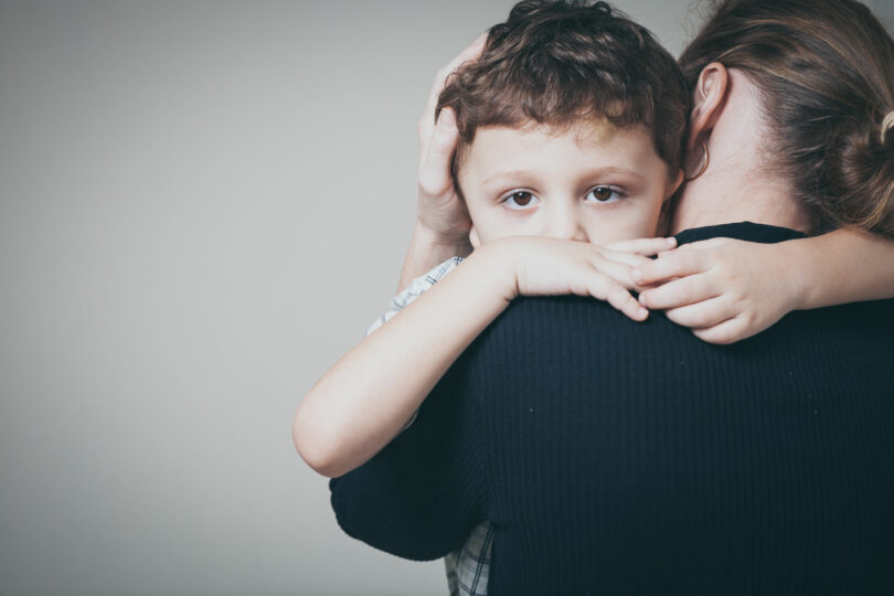 filho triste abraçando sua mãe em casa.