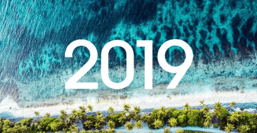 Fundo de praia vista de cima. Mar areia e árvores. 2019 em branco em cima da imagem.