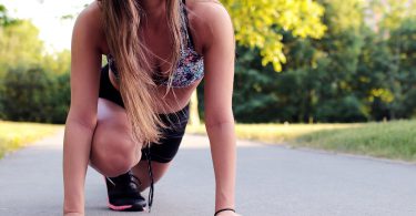 Mulher agachada em posição de largada de corrida