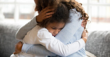 Mãe e filha se abraçando.