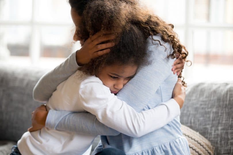 Mãe e filha se abraçando.