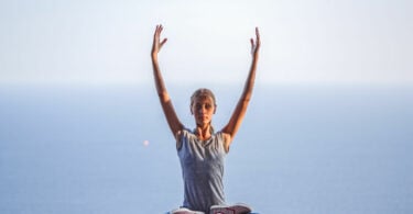 Menina em posição de lotus fazendo yoga.