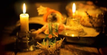 Velas, incensos e palhas colocados em cima de mesa de madeira.