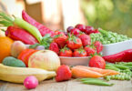 Frutas e verduras naturais em cima de uma mesa de madeira.