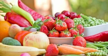 Frutas e verduras naturais em cima de uma mesa de madeira.