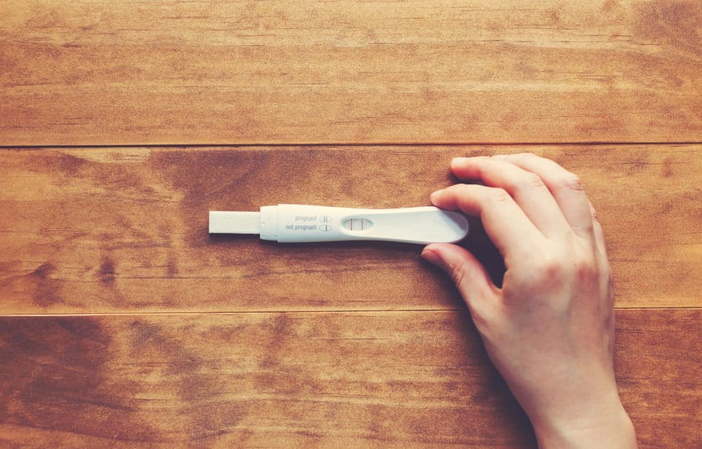 Mão feminina segura teste de gravidez