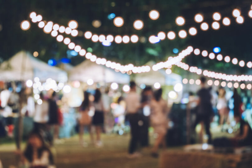 Foto desfocada de feira de festividades com muitas luzes.