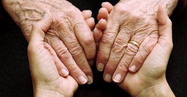 Mãos de um idoso ou idosa e mãos de uma jovem. Gerações se encontrando.