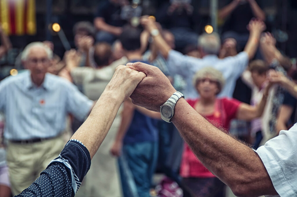 Grupo de idosos segurando as mãos em rodas. Celebrando suas culturas.