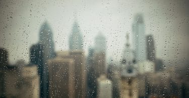 Vista de uma cidade de uma janela com o vidro molhado.