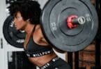Imagem de uma mulher na academia levantando peso