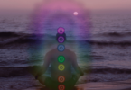 Pessoa na praia meditando, ilustrando a energia dos chakras