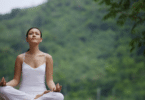 Mulher meditando. No fundo, há várias árvores