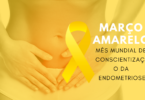 Mulher com as mãos na região abdominal baixa com fundo amarelo. Mês Mundial da Conscientização da Endometriose.