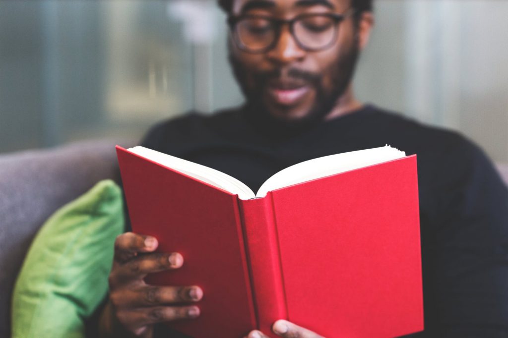 Homem sentado lendo um livro.