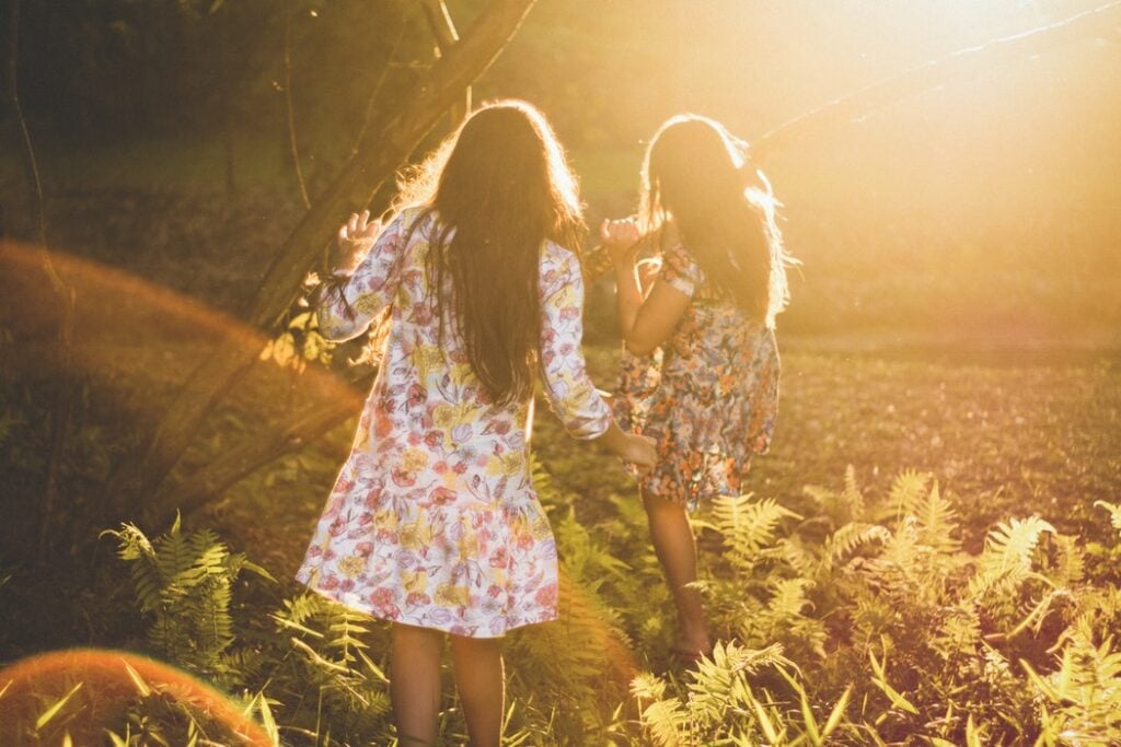 Meninas brincando em uma floresta.