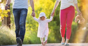 Pais e filhos andando de mãos dadas.