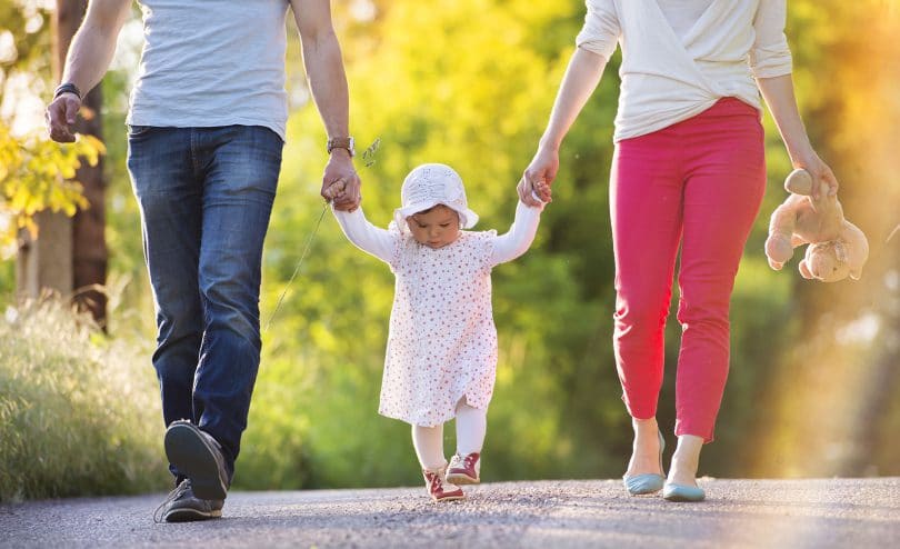 Pais e filhos andando de mãos dadas.