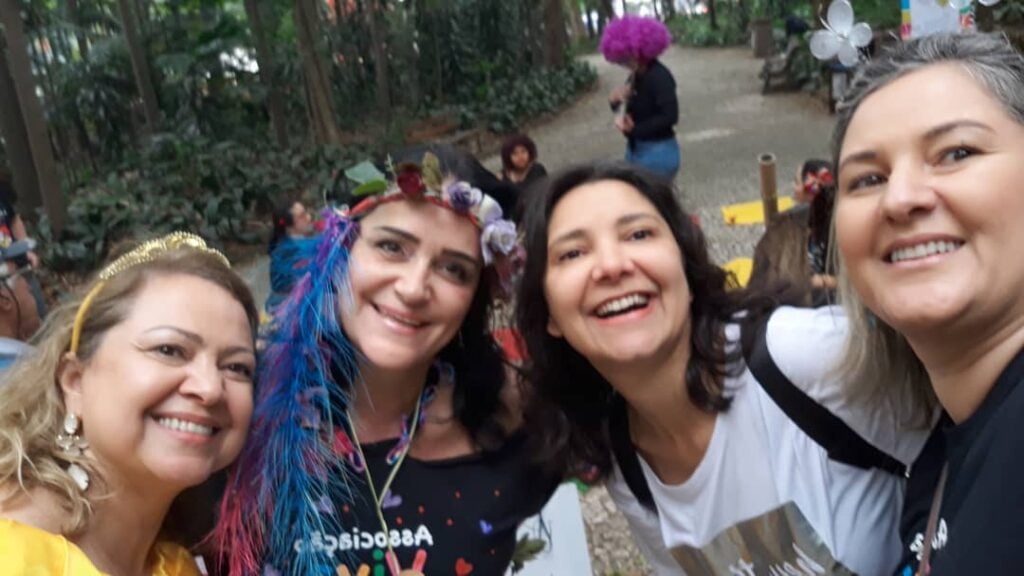 Foto da colunista com outros companheiras do grupo de trabalho voluntário, em um parque, durante um evento de leitura.