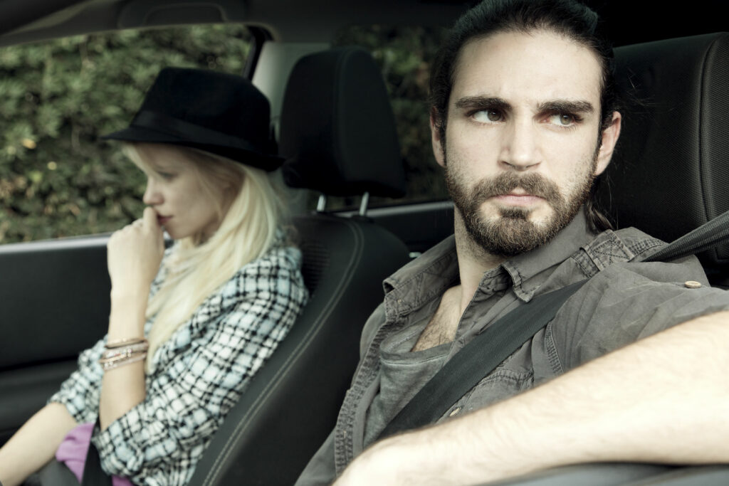 casal dentro do carro olhando em direções opostas depois de uma briga.